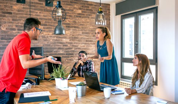 Young coworkers arguing standing in the office