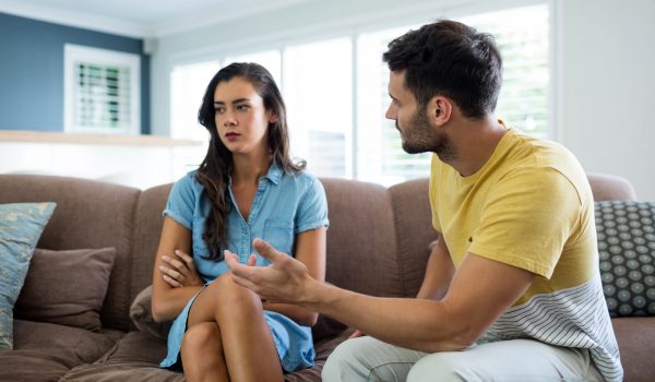 Couple arguing with each other in living room at home